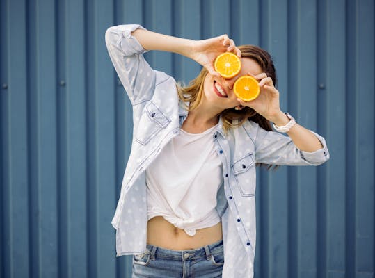 Jonge vrouw met halve sinaasappels voor haar ogen