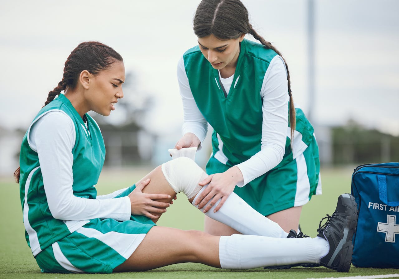 Jonge vrouw in voetbaltenue wordt verbonden op het veld
