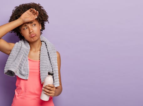 jonge sportieve vrouw kijkt sip door zweet