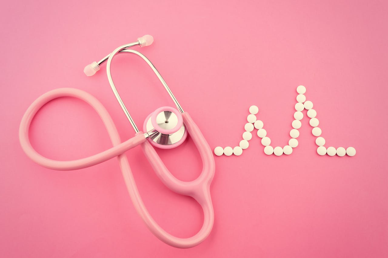roze stethoscoop met roze achtergrond en hartpulse van pillen