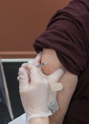 Een persoon krijgt een vaccin toegediend van een andere persoon.