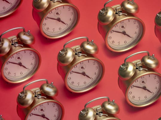 Gouden wekkers op een rode ondergrond.