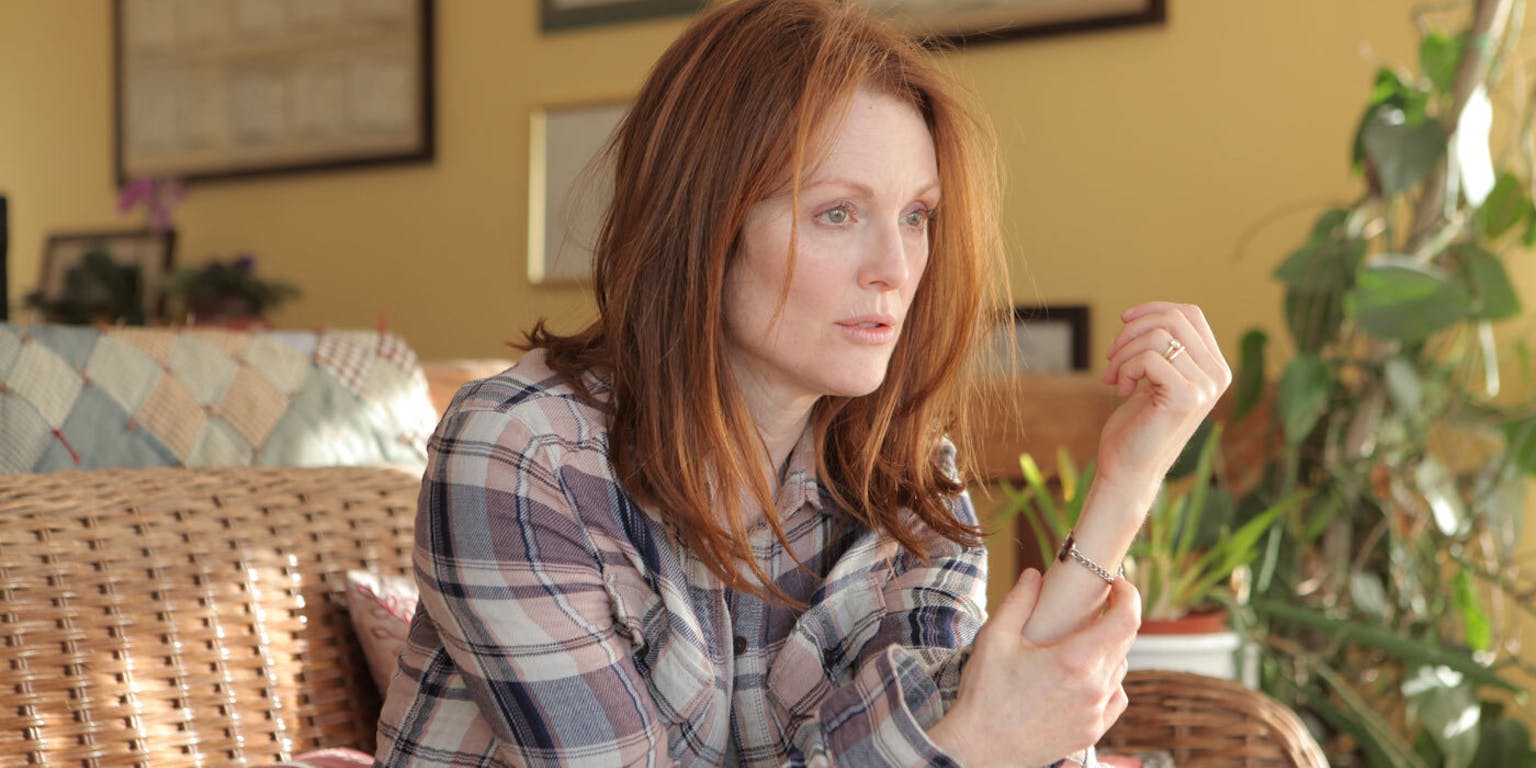 Een vrouw met rood haar, zittend op een rieten stoel.