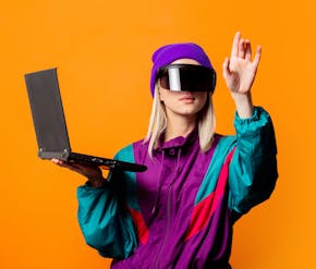 jonge vrouw met verschillende technologie: oculus bril en laptop in kleurrijke omgeving