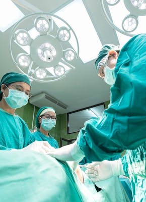 Chirurgen opereren een patiënt in een operatiekamer.