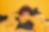 Jonge vrouw wordt bedolven door kleding