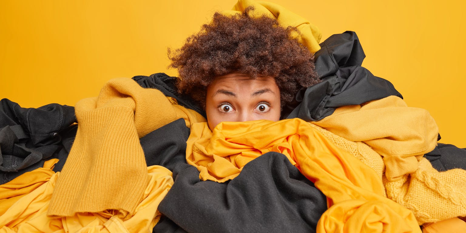 Jonge vrouw wordt bedolven door kleding