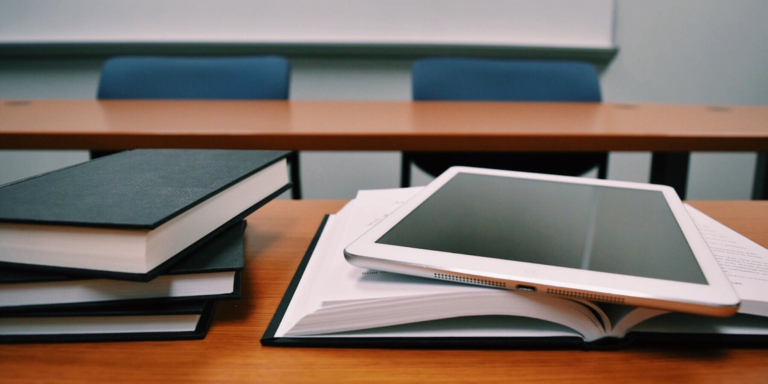 Een tablet boven op een boek.