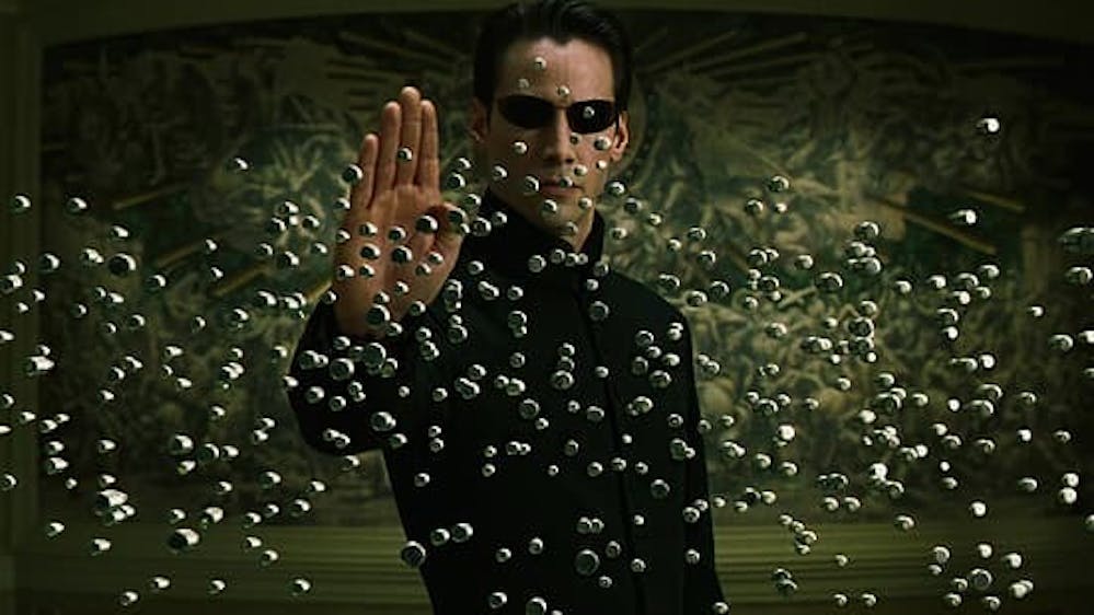Scene uit de film The Matrix Reloaded, waarin hoofdpersoon Neo met een simpel handgebaar kogels tegenhoudt in de schijnwereld van de Matrix