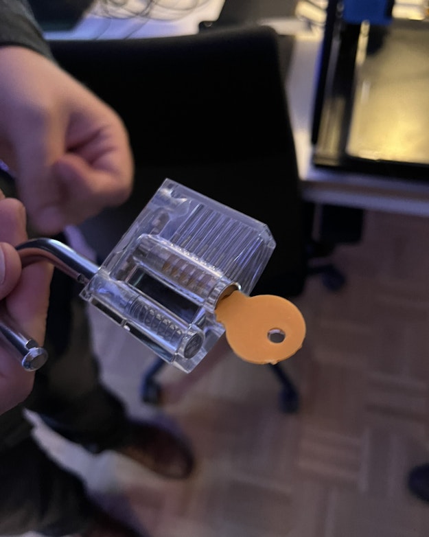 Een 3D-geprinte sleutel opent een hangslot.