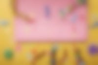 roze laptop met kleurige feestartikelen eromheen