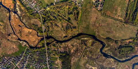 Luchtfoto van een kronkelende rivier in bewoond landschap