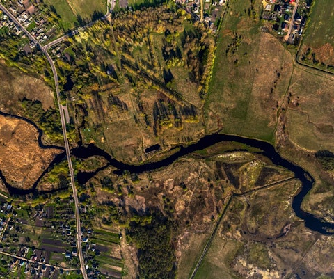 Luchtfoto van een kronkelende rivier in bewoond landschap
