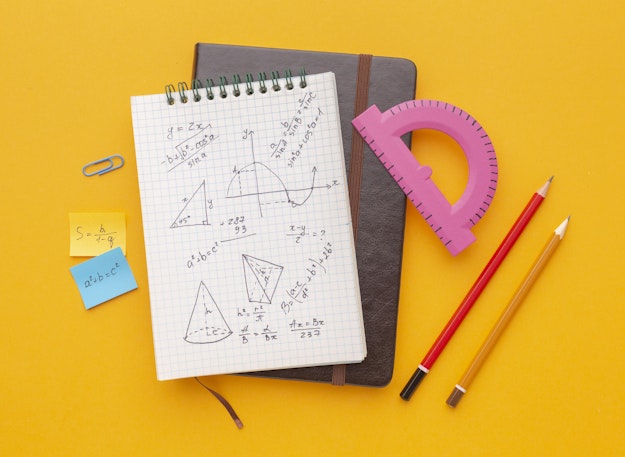wiskundige attributen: rekenmachine, meetlat, potloden en notitieboekje met wiskundige berekeningen zoals de stelling van phytagoras