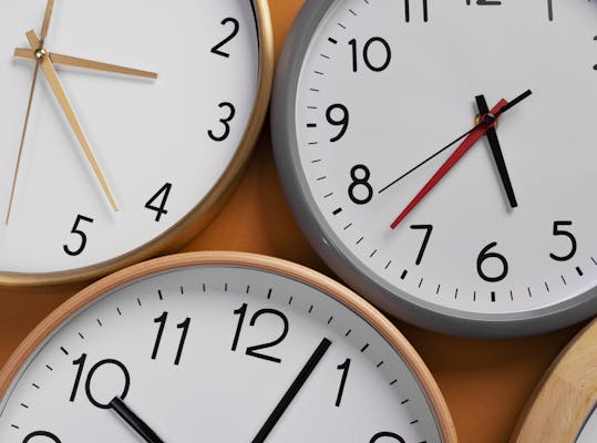 Stilleven van een aantal klokken tegen een muur.