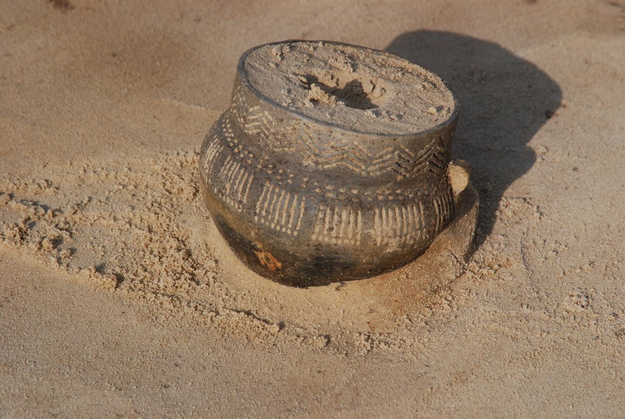 Versierde trechterbeker als grafgift in het zand.