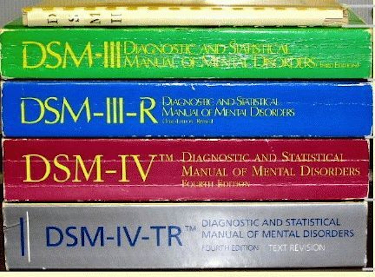 5 verschillende edities van DSM boeken zijn op elkaar gestapeld.