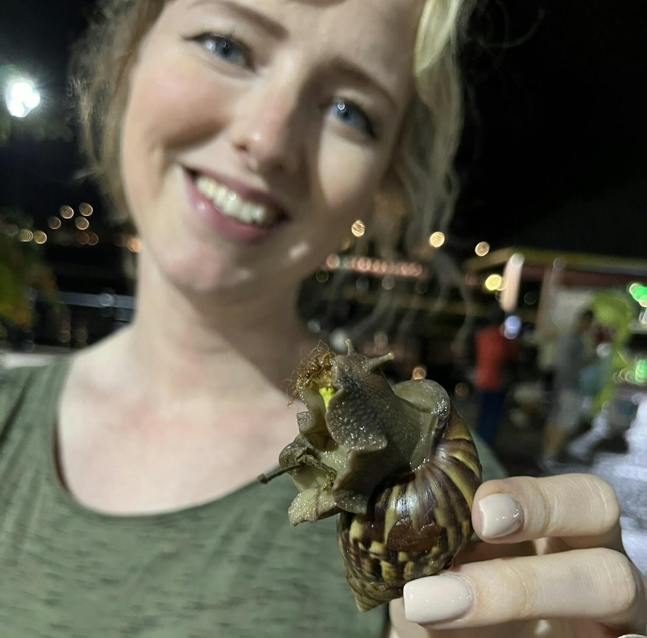 Manon de Visser houdt een Afrikaanse reuzeslak vast op Borneo