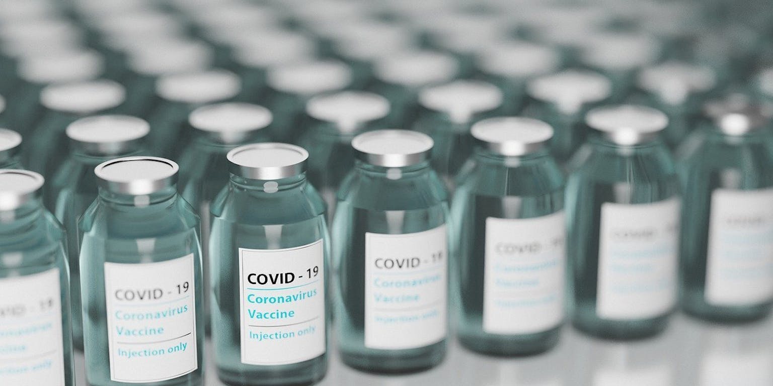 Coronavirusvaccins in flessen opgesteld op een tafel.
