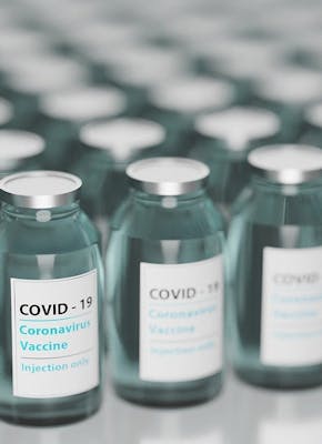 Coronavirusvaccins in flessen opgesteld op een tafel.