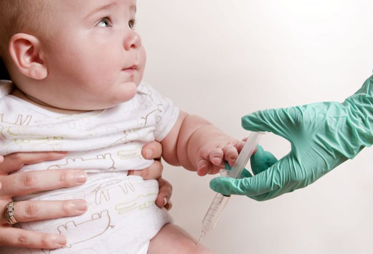 Een baby wordt geïnjecteerd met een injectiespuit.