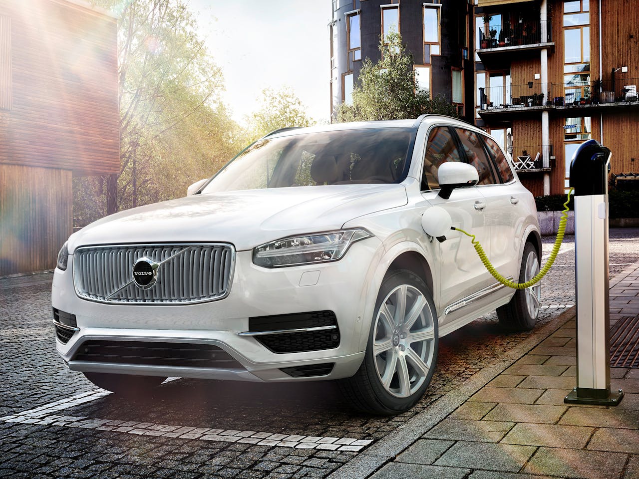 Een witte Volvo XC90 SUV aangesloten op een laadstation.