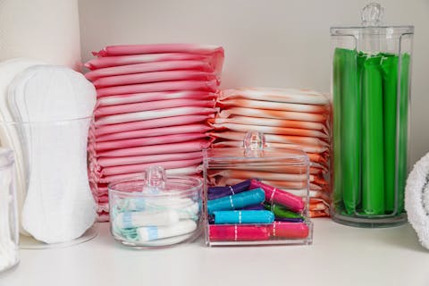 Op steeds meer scholen en in veel horecagelegenheden zijn menstruatieproducten gratis beschikbaar Plankje met schaaltjes tampons en stapels maandverband