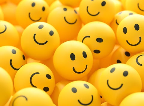 Veel gele balletjes met een smiley erop