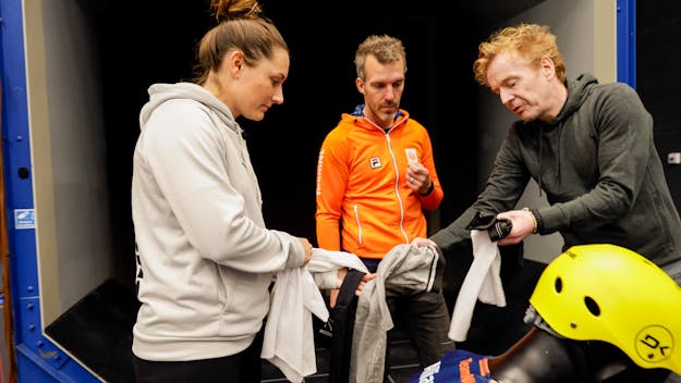 Anneloes Lammerts (kitesurfer), Wouter Terra (midden) en Hank Zieverink (WEEV Textiles) bekijken het nieuwe kitesurfpak. Drie mensen tonen een nieuw kitesurfpak