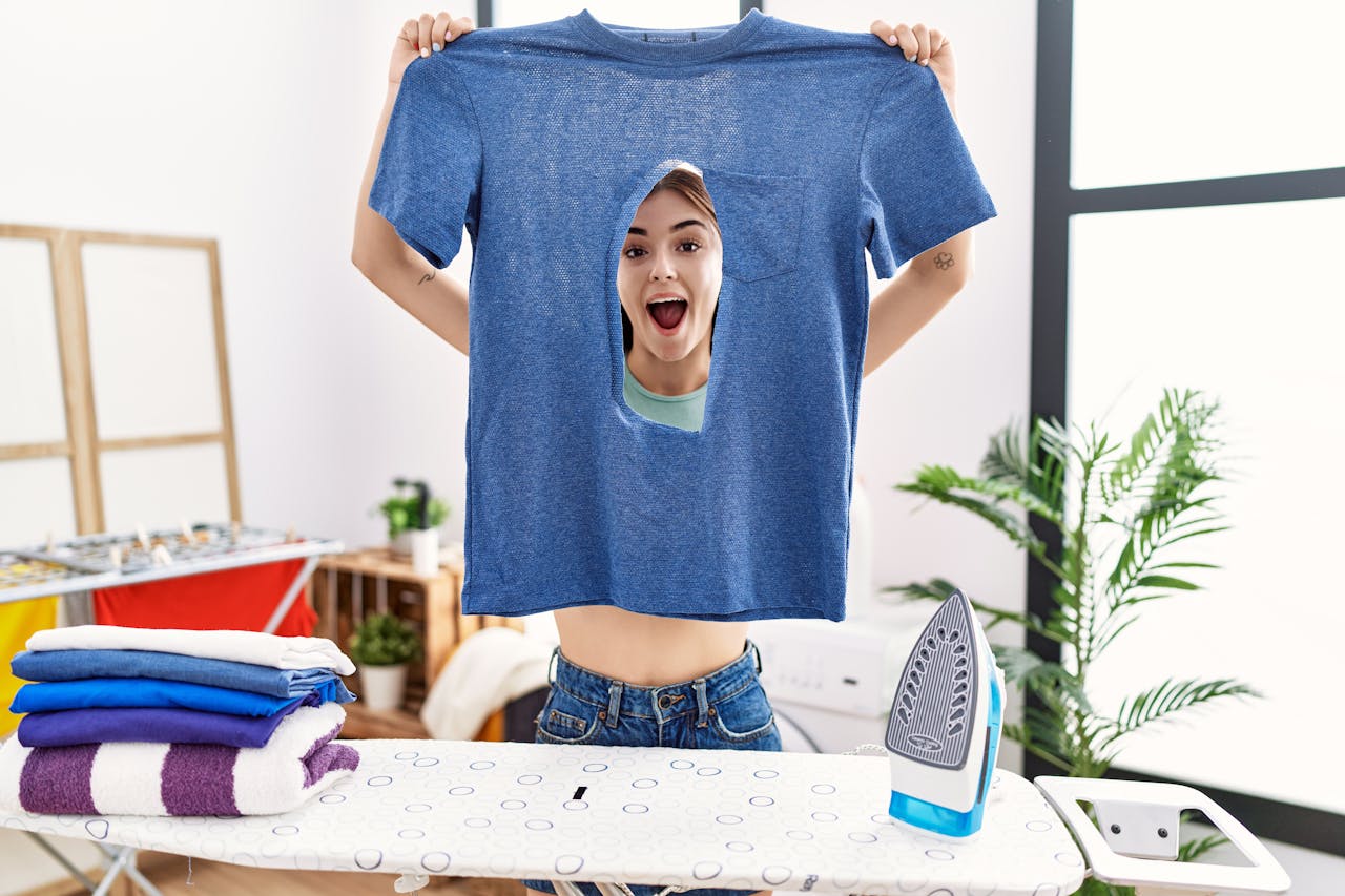 Na al die zomerpret, is je favoriete shirt stuk. Jonge vrouw kijkt paniekerig naar gat in haar shirt